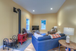 Living room with smart TV and wood-burning fireplace.