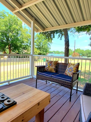 Large covered front porch with a view of the lake across the street. 