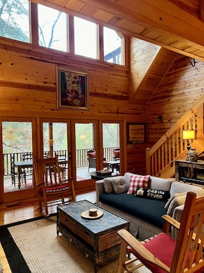 Main living room leads to outdoor dining room & wrap around porch w/ river views