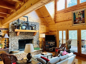 Main floor living area w/ woodburning fireplace, vaulted ceiling, river views.
