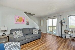 Open concept living area with private balcony access, queen size sleeper sofa, and flat screen TV