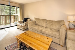 Living room with balcony access, wood burning fireplace and TV