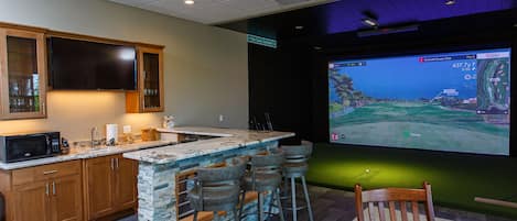 Finished walkout basement is a entertainment center with golf simulator, bar, large screen TV and fireplace.