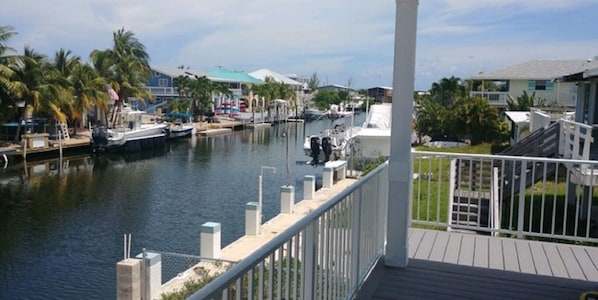 Spacious covered porch with views of 80ft wide deep water canal . 60 ft dock