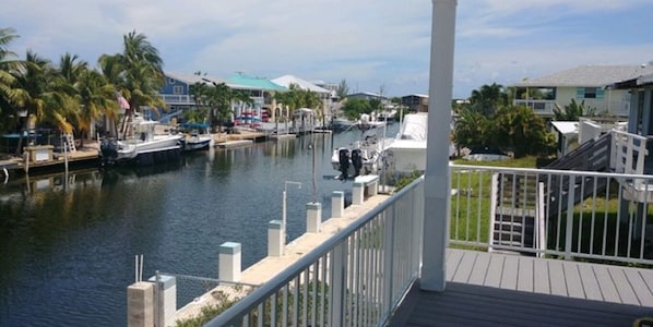 Spacious covered porch with views of 80ft wide deep water canal . 60 ft dock 