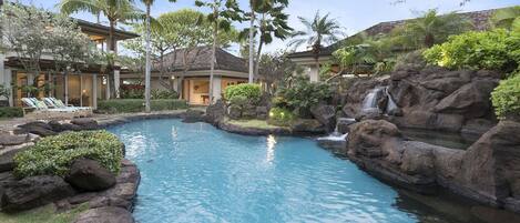 Tropical lagoon style pool with natural rocks and cascading waterfalls.