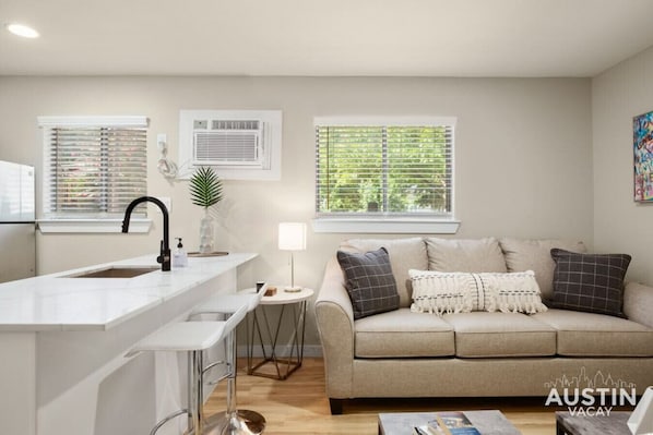 Living room with sleeper sofa and kitchen with bar seating