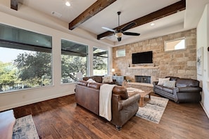 Living room with large pictures windows looking out towards the pool and lake