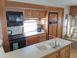 Spacious kitchen with microwave, gas stovetop, oven, refrigerator and more
