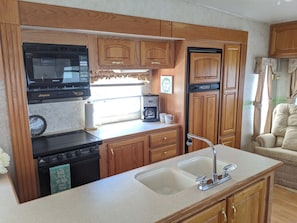Spacious kitchen with microwave, gas stovetop, oven, refrigerator and more
