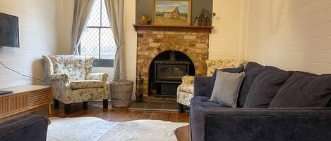 Living room with wood burning fireplace and aircon