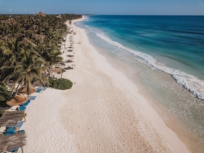 Tulum beach with Mahayana shade palapas and blue loungers