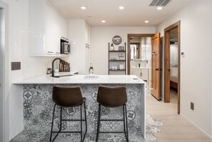 Efficiency Kitchen featuring a refrigerator and laundry.  Induction counter-top