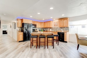 Full Kitchen with bar stools and granite countertops