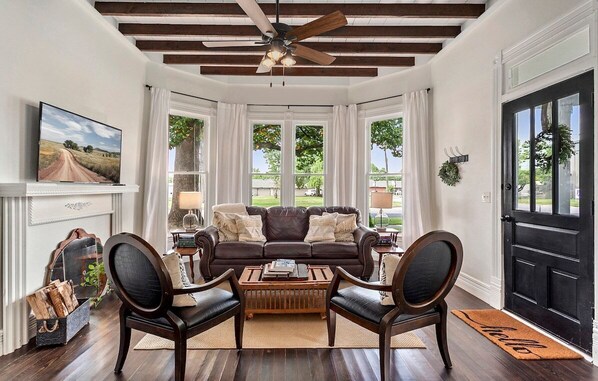 Living room features bay window and original beamed ceiling.