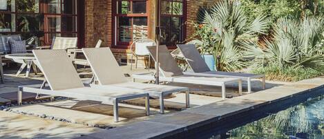 Pool loungers overlooking the pool and green space