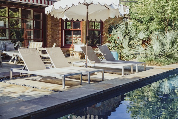 Pool loungers overlooking the pool and green space