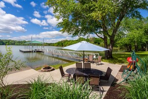 Waterfront patio with private dock, firepit, and kayaks