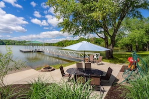 Waterfront patio with private dock, firepit, and kayaks