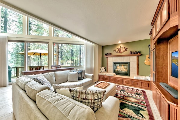 The great room features a stunning wall of windows, gas fireplace, and 48" TV