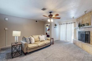Spacious living room has a ceiling fan and also is a great gathering space.
