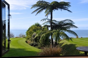 View from the Honeymoon Cottage bedroom.  A private lawn in front stretches down to meet the beach