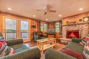 Comfortable living room with wood burning fireplace overlooking lake