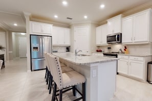 The open kitchen features granite counters, full sized upgraded appliances, and all the cooking and serving items you should need.