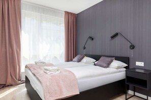 Natural light fills the bedroom, enhancing its cozy atmosphere.