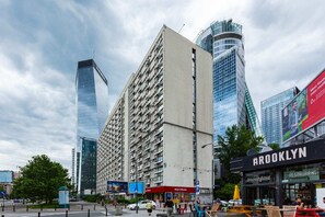 An urban street view featuring tall modern buildings, a vibrant city atmosphere, and clear skies.