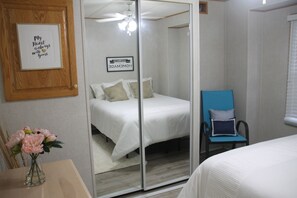 Master bedroom with queen bed and mirror door closet