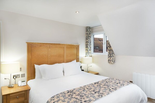 Elegant bedroom with luxurious bedding and charming decor accents.