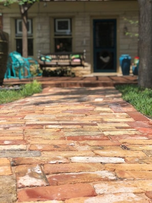 Antique brick walkway leading to The Carriage House with parking out front.