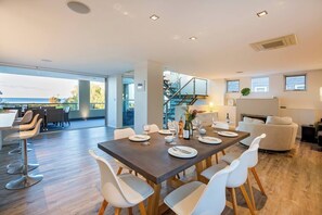 Dine inside around the eight-seater table or out on the balcony—both offering oceanside vistas.