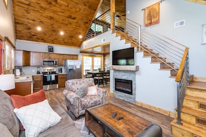 Angel's View Cabin living room with custom metal handrail, rustic cabin decor, fireplace, and vaulted ceilings. This cabin is located in Red River Gorge, KY.