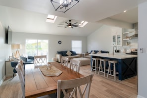 Open concept dining area and kitchen overlooking the living room and flat screen TV.