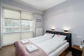 Another bedroom with a double bed, soft bedding, and light pastel decor.