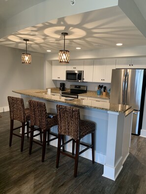 Beautiful white kitchen with granite tops and new stainless appliances.