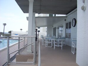 Covered patio seating overlooks gorgeous heated pool & spectacular beachfront