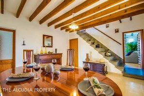 Entrance area with dining table and access to the living room, the kitchen and the upper bedrooms in Finca Pegasus Alcudia