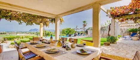 Trevlig terrass för att njuta av utomhusmåltider skyddade från solen med vacker utsikt över havet och bukten Alcudia Finca Pegasus på Alcudia Mallorca