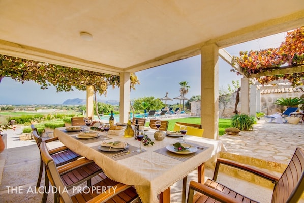 Dejlig terrasse til at nyde udendørs måltider beskyttet mod solen med smuk udsigt over havet og bugten Alcudia Finca Pegasus på Alcudia Mallorca