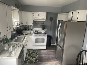 Kitchen with refrigerator, dishwasher, coffee maker, oven etc.