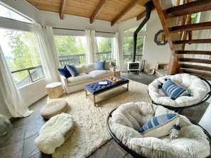 Cozy bright living room with partial view to the lake and tree tops