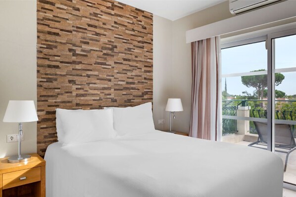 Bedroom with a comfortable bed and a textured accent wall.