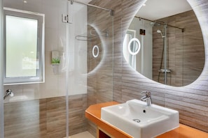 Bathroom with a clear shower space and wooden details.