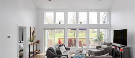 Open Concept Living Room w/ Cathemeral Ceilings & Wall High Windows