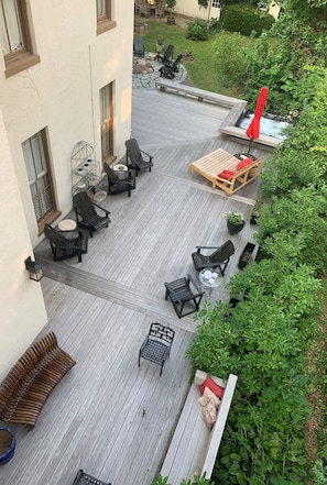 Partial view of mahogany deck with multiple seating areas and hot tub at end.