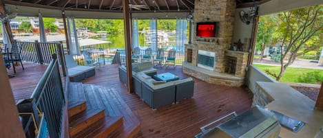 Comfy couches, tv, grill, fireplace, fans- an amazing outdoor space next to lake