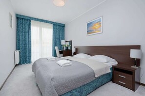 Comfy bedroom with desk, chair, double bed, nightstand, night lamp, mirror and wardrobe.